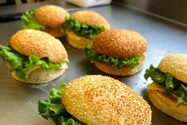 Assemblage des burgers artisanaux avec buns faits main au laboratoire de la boulangerie pâtisserie La Talemelerie Ampère à Grenoble